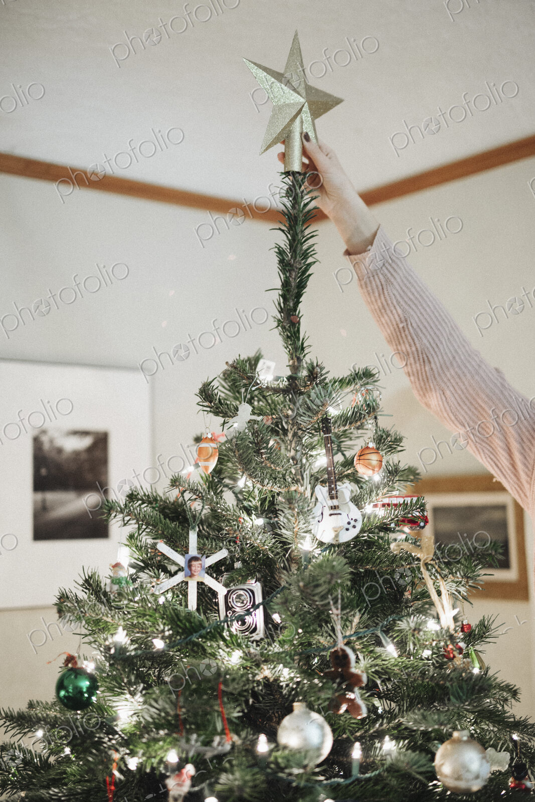 A person decorating a Christmas tree at home.