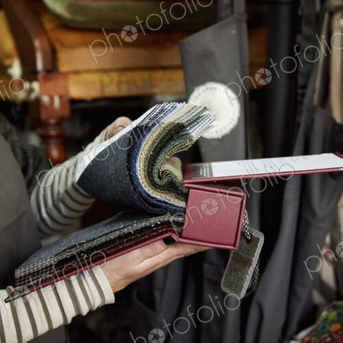 A person flicking through a fabric sample book, looking at colours and patterns. A person flicking through a fabric sample book, looking at colours and patterns.