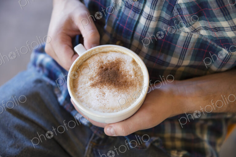 A person holding a cup of coffee in two hands.