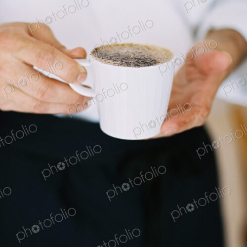 A person holding a full cup of coffee. A person holding a full cup of coffee.