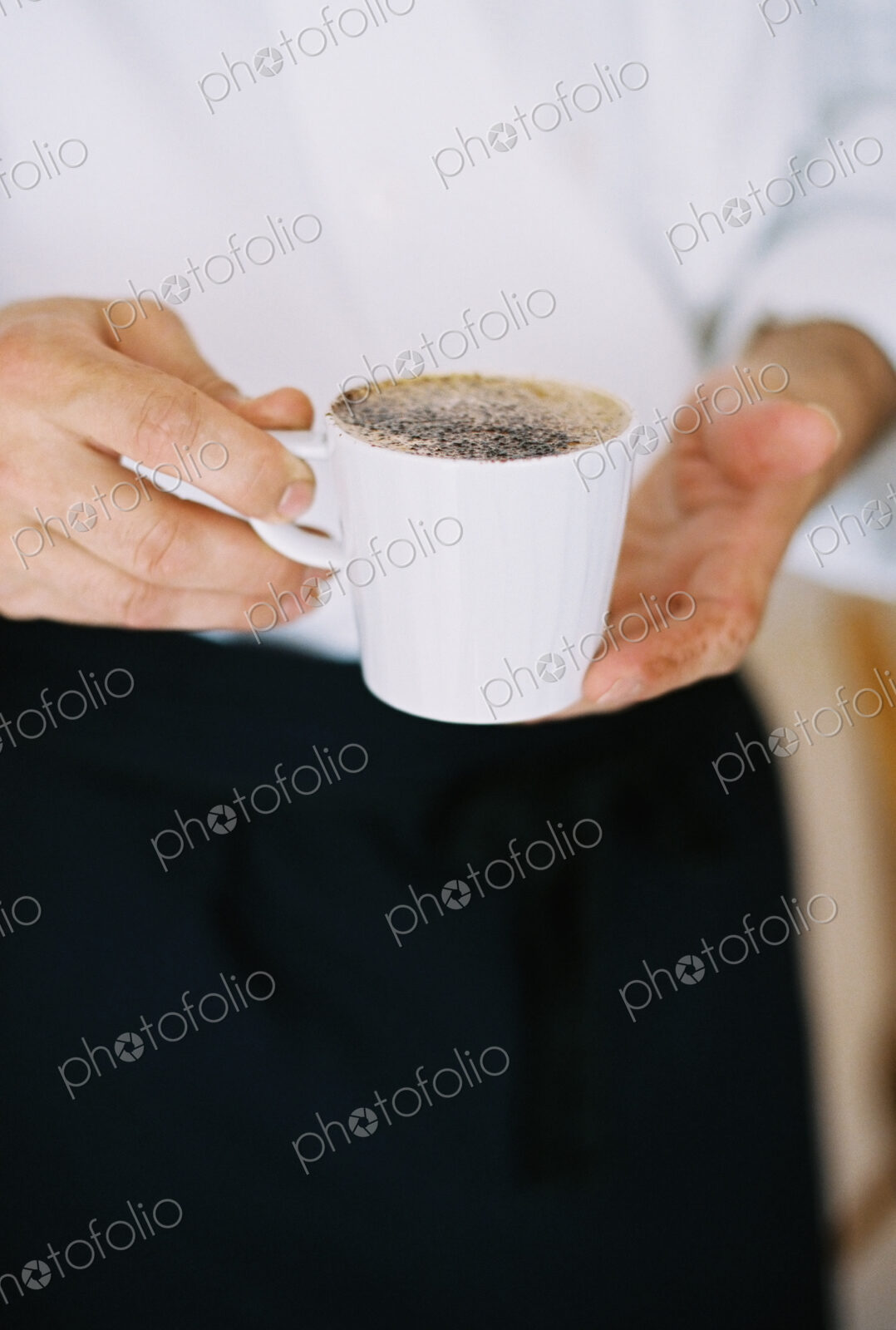 A person holding a full cup of coffee.