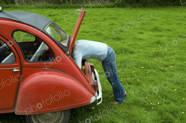 A person leaning in to the boot at the rear of the car.