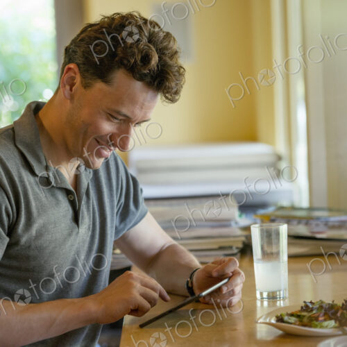 A person sitting alone in a cafe. A man using a digital tablet. A person sitting alone in a cafe. A man using a digital tablet.