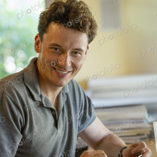 A person sitting alone in a cafe. A man using a digital tablet. A person sitting alone in a cafe. A man using a digital tablet.