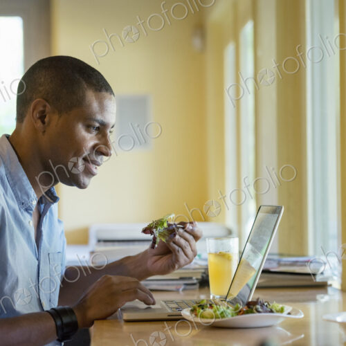A person sitting alone in a cafe. A man working on a laptop. A person sitting alone in a cafe. A man working on a laptop.