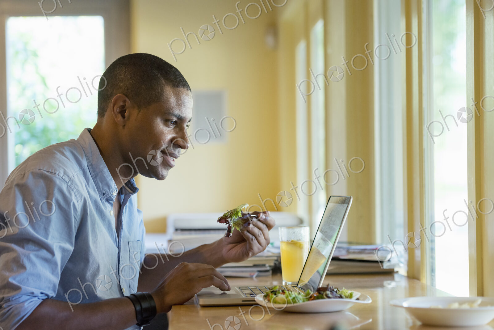 A person sitting alone in a cafe. A man working on a laptop.