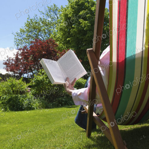 A person sitting in a deckchair, reading.