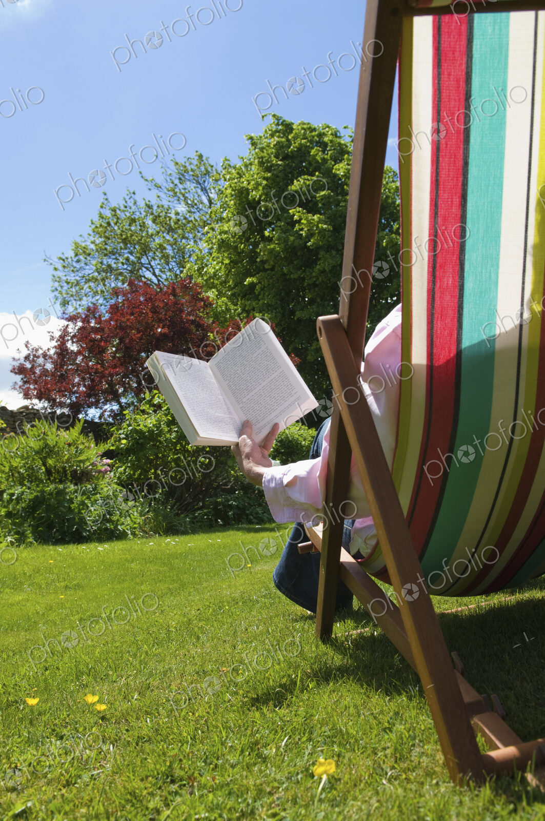 A person sitting in a deckchair, reading.