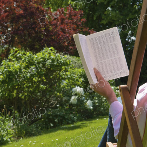 A person sitting in a deckchair, reading.