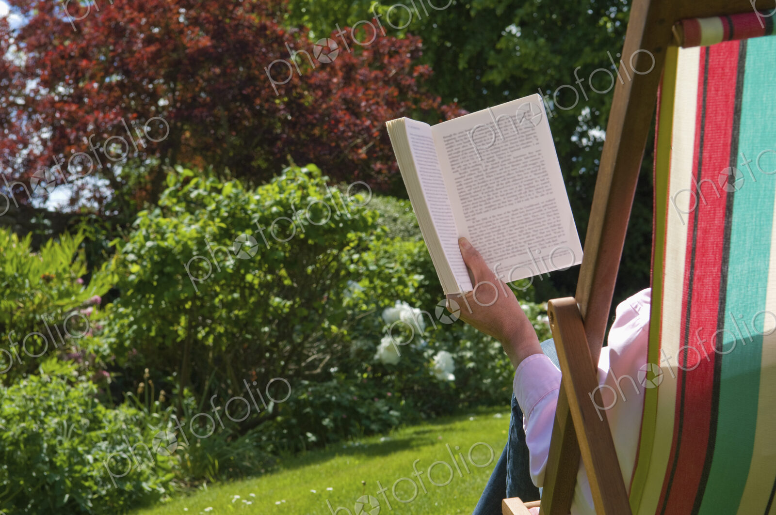 A person sitting in a deckchair, reading.