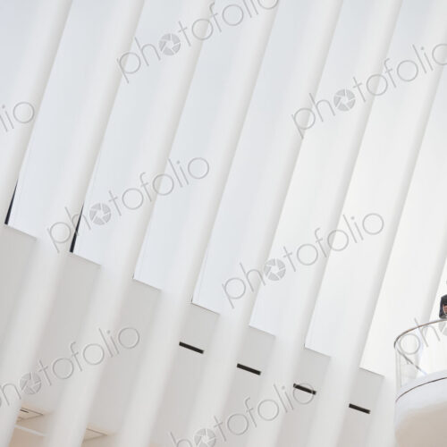A person standing alone in an atrium by a railing, alone in a large space. A person standing alone in an atrium by a railing, alone in a large space.