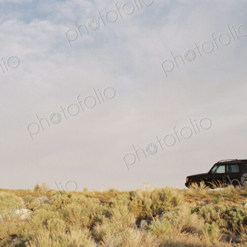 A person standing by the open rear door of a 4x4 vehicle. A person standing by the open rear door of a 4x4 vehicle.