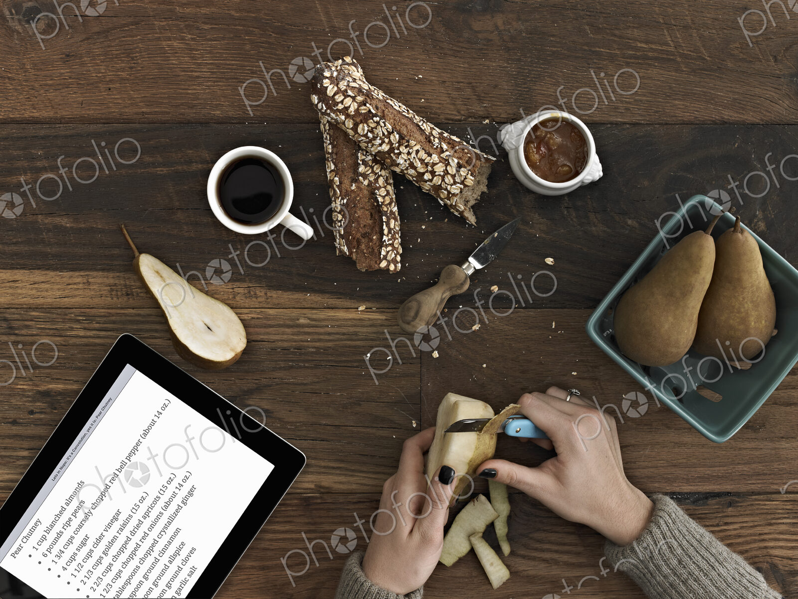A person using a peeling knife to peel a pear. A computer tablet device with the…
