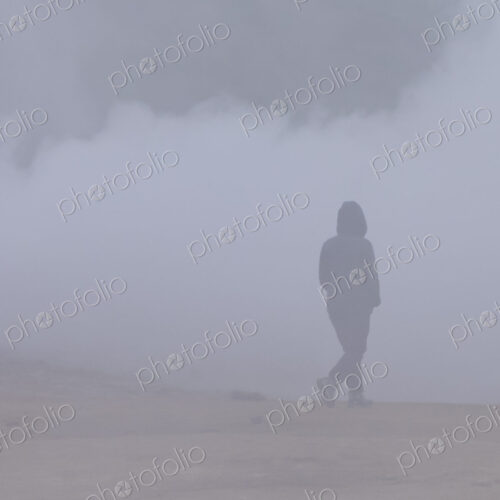 A person walking through the vapour and steam from the hot springs. A person walking through the vapour and steam from the hot springs.