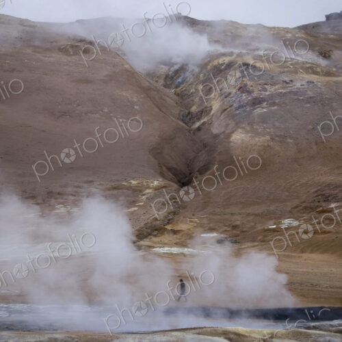 A person walks along the steamy edge of a hot spring. A person walks along the steamy edge of a hot spring.