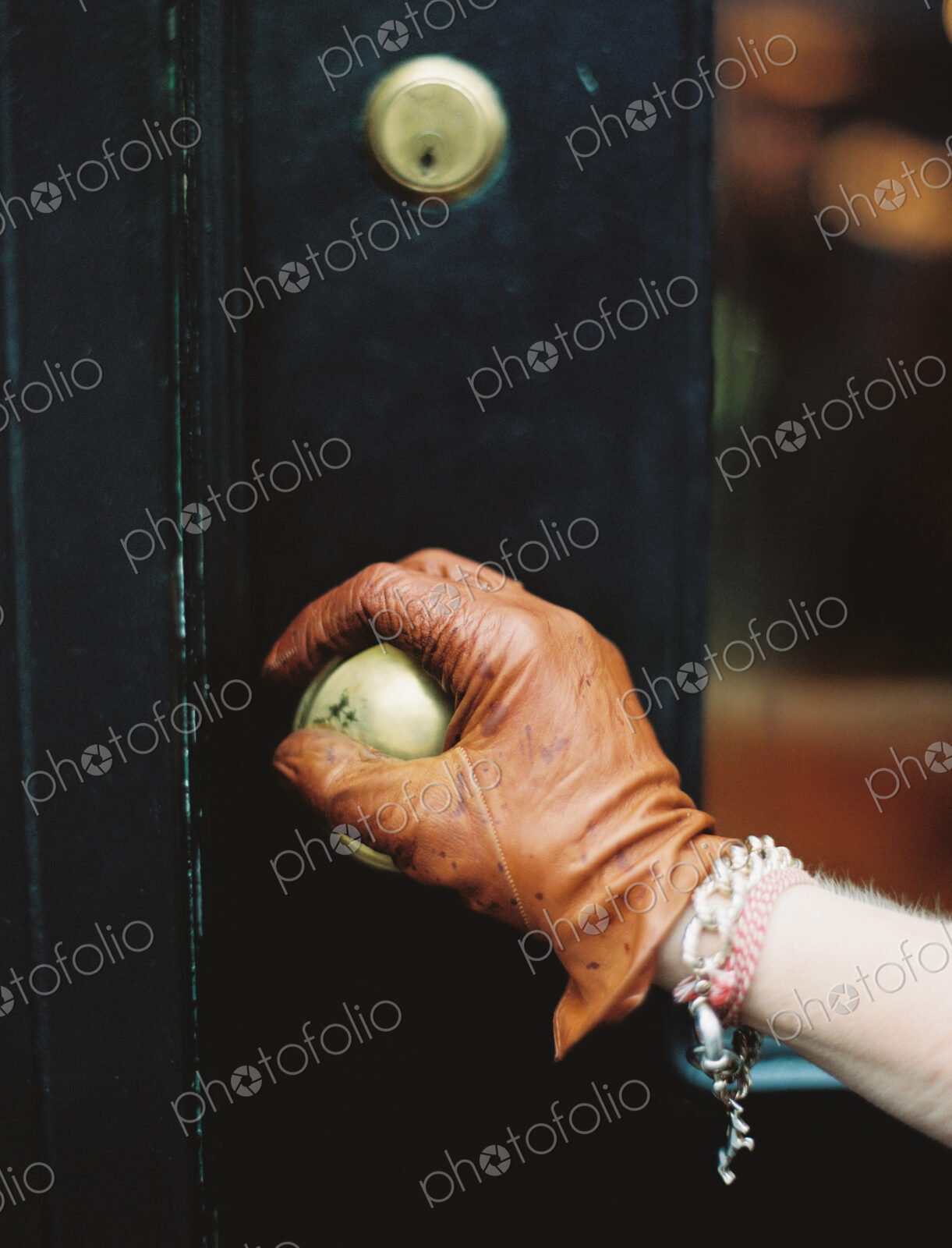 A person wearing a leather glove, opening a door.
