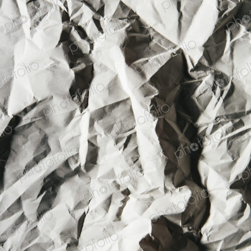 A piece of recycled white paper, crumpled and scrunched up, refuse.