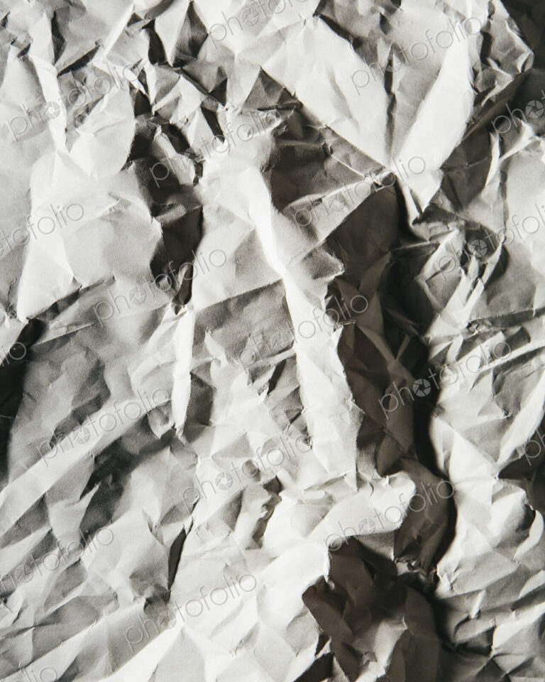 A piece of recycled white paper, crumpled and scrunched up, refuse.