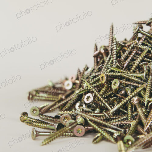 A pile of brass screws with a Philips crosshead.