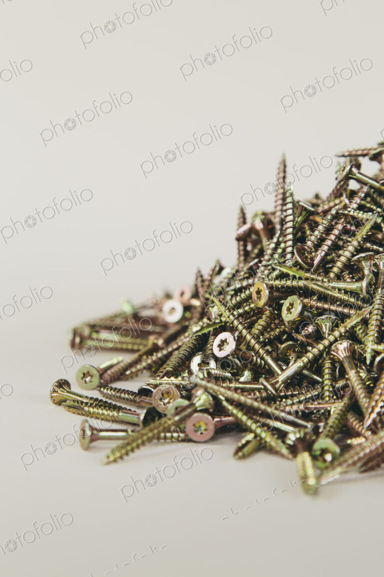 A pile of brass screws with a Philips crosshead.