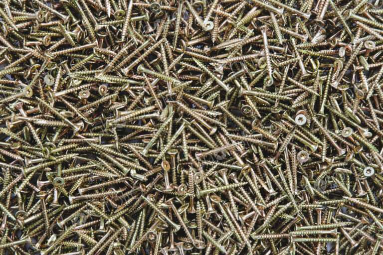 A pile of brass screws with a screw thread.