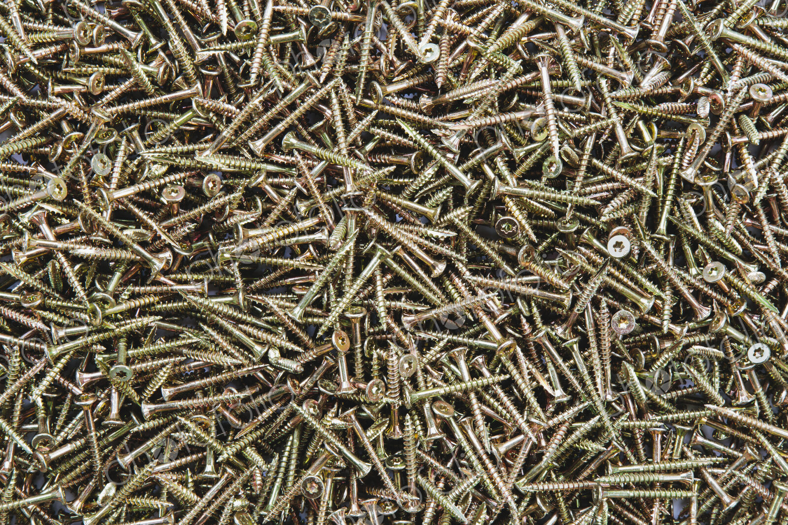A pile of brass screws with a screw thread.