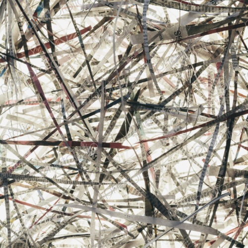 A pile of long thin shredded pieces of printed newspapers.