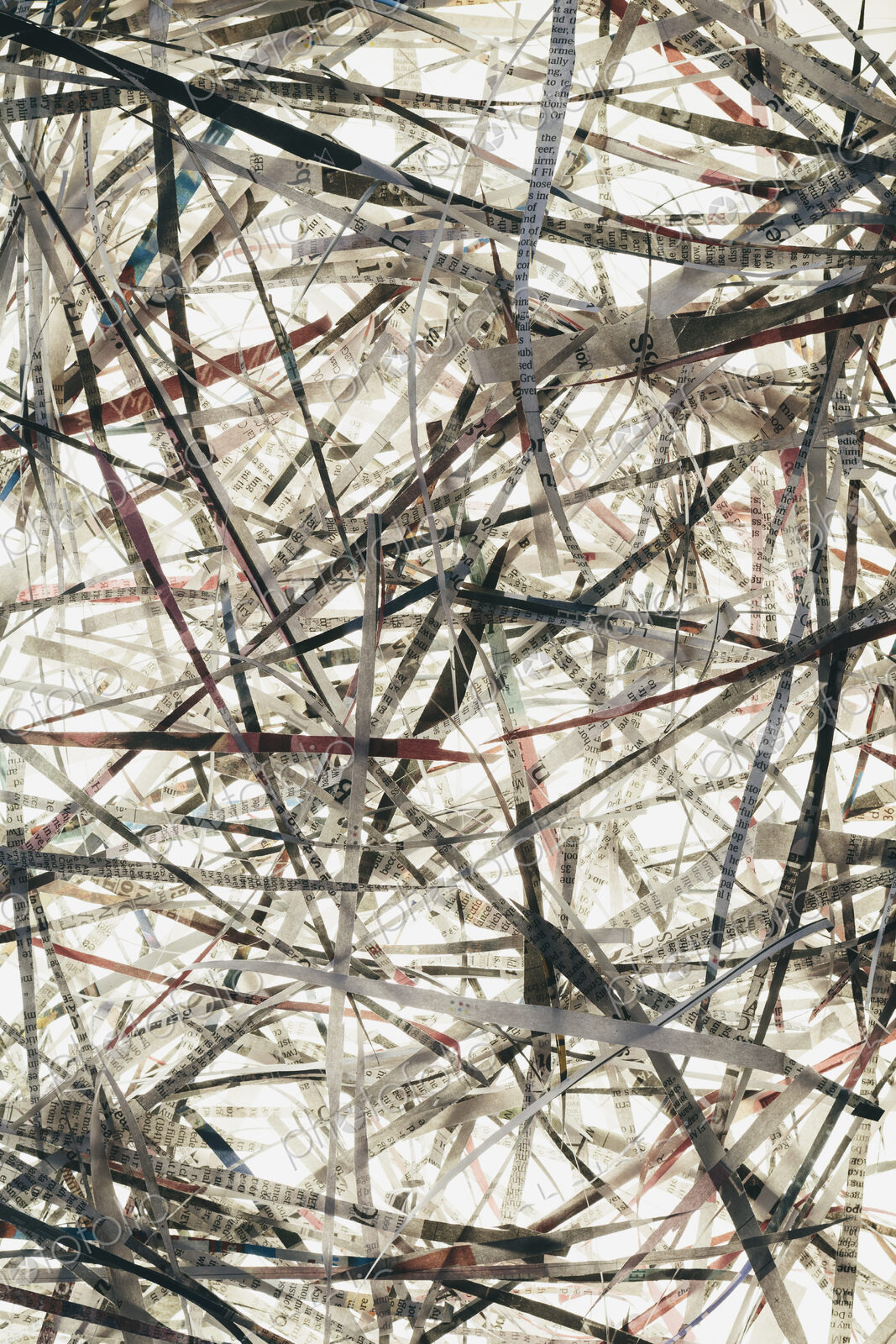 A pile of long thin shredded pieces of printed newspapers.