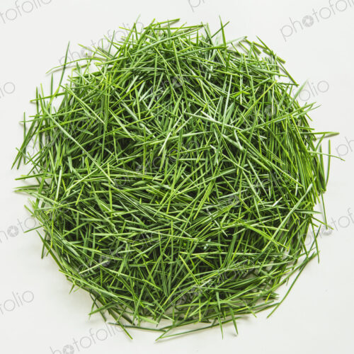 A pile of organic wheatgrass on a white background