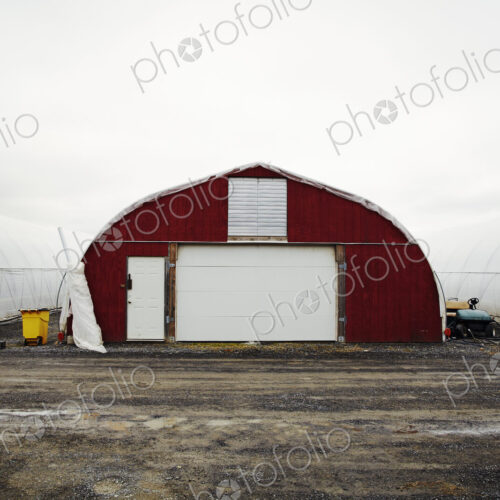 A plant nursery with polytunnels, buildings with ventilation and doors, and white… A plant nursery with polytunnels, buildings with ventilation and doors, and white…
