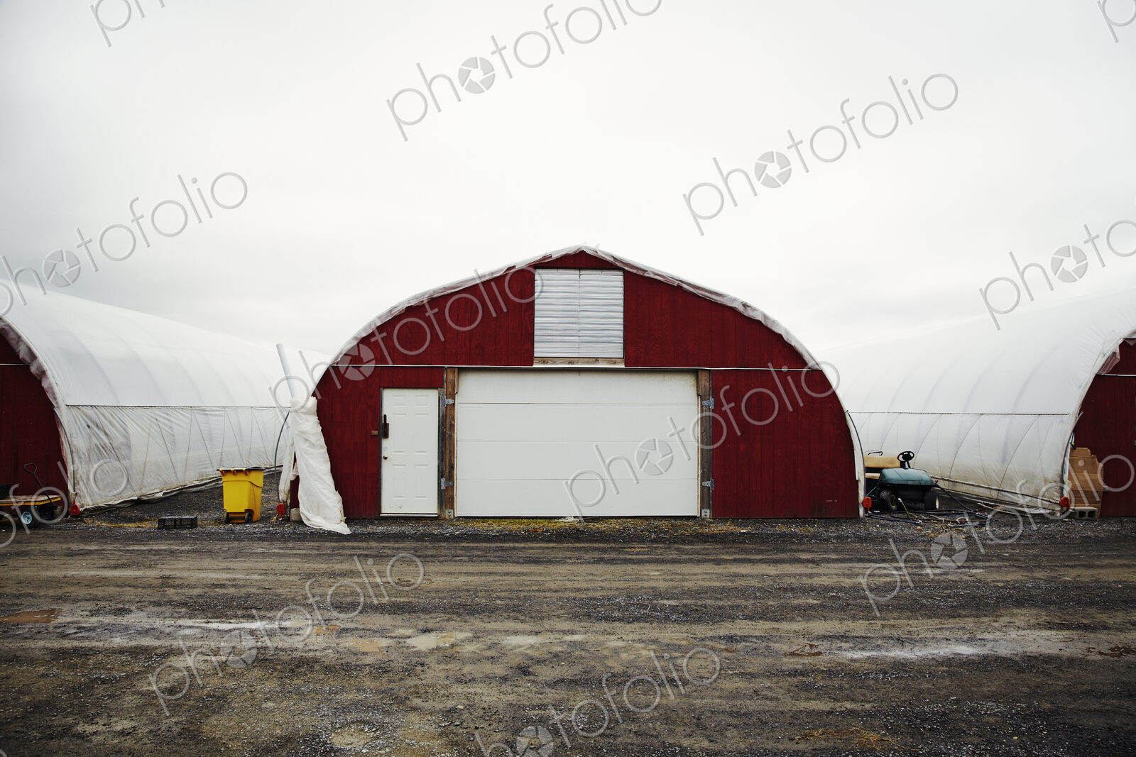 A plant nursery with polytunnels, buildings with ventilation and doors, and white…