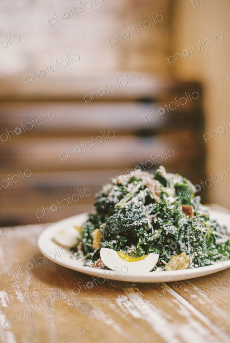 A plate of cooked vegetables and soft boiled eggs, with garnishes.