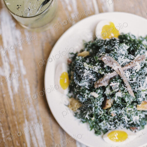 A plate of cooked vegetables and soft boiled eggs, with garnishes.A glass of chilled… A plate of cooked vegetables and soft boiled eggs, with garnishes.A glass of chilled…