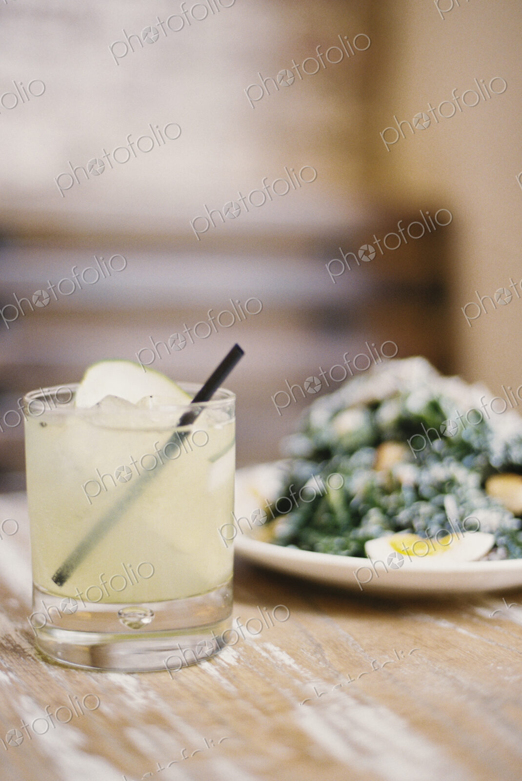 A plate of cooked vegetables and soft boiled eggs, with garnishes.A glass of chilled…