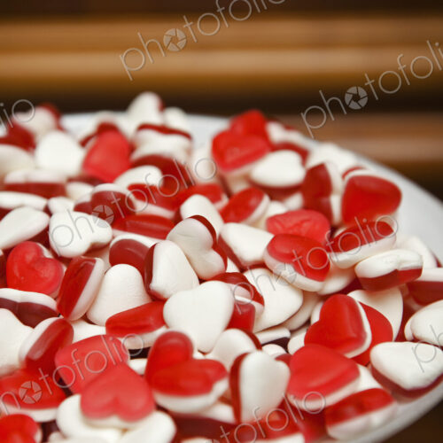 A plate of red and white heart-shaped sweets. A plate of red and white heart-shaped sweets.