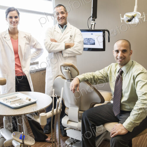 A portrait of a Mixed Race team of dentists in a dental examination room. A portrait of a Mixed Race team of dentists in a dental examination room.