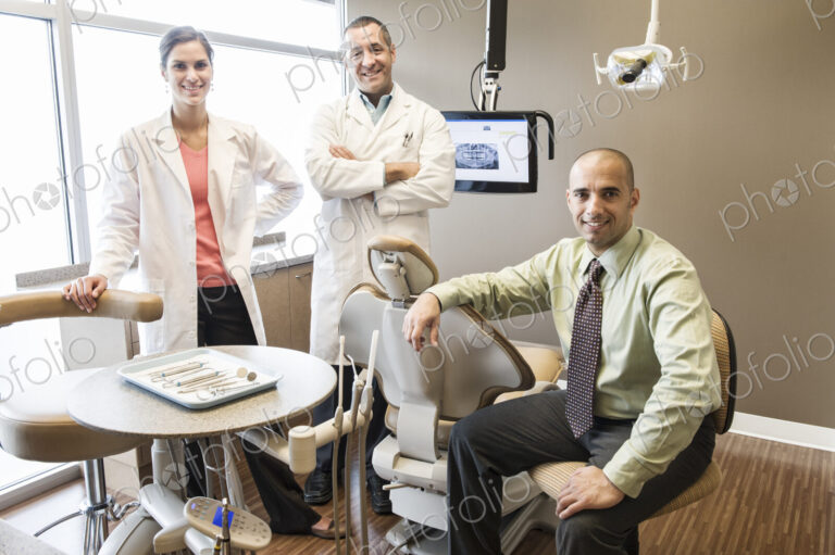 A portrait of a Mixed Race team of dentists in a dental examination room.
