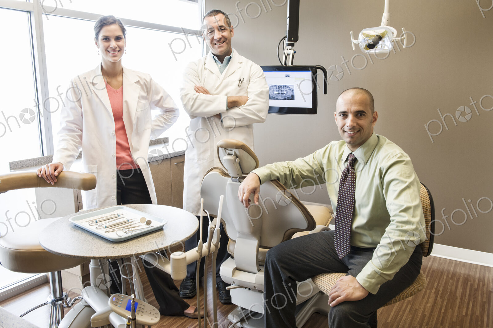 A portrait of a Mixed Race team of dentists in a dental examination room.