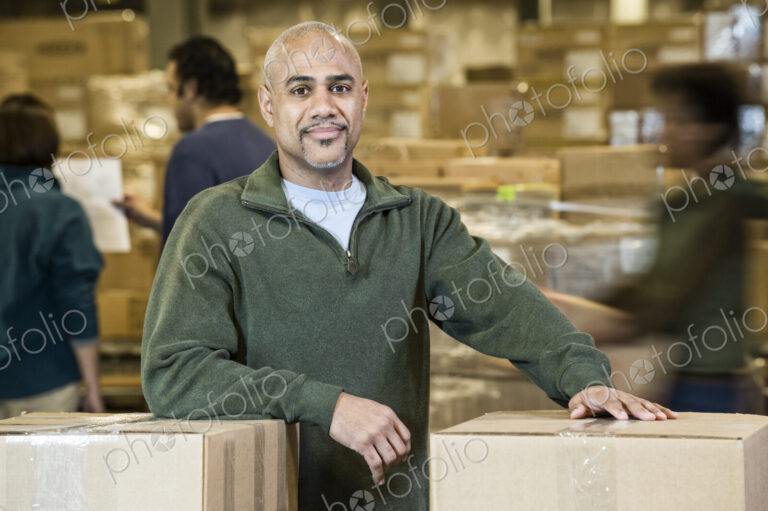 A portrait of a black warehouse business manager. surrounded by storage boxes and…