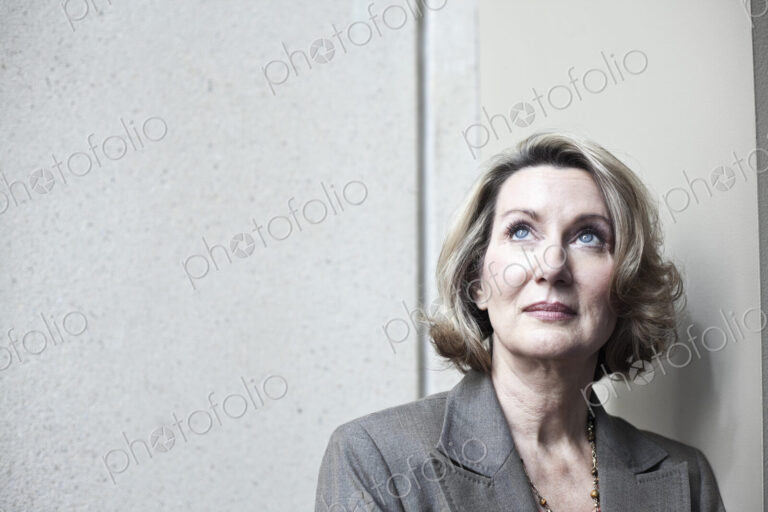 A portrait of a caucasian businesswoman looking up.