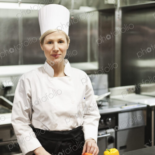 A portrait of a caucasian female chef in a commercial kithchen.