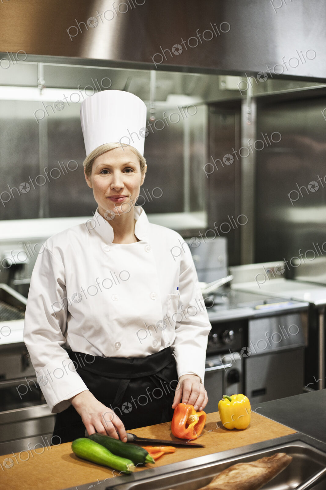 A portrait of a caucasian female chef in a commercial kithchen.