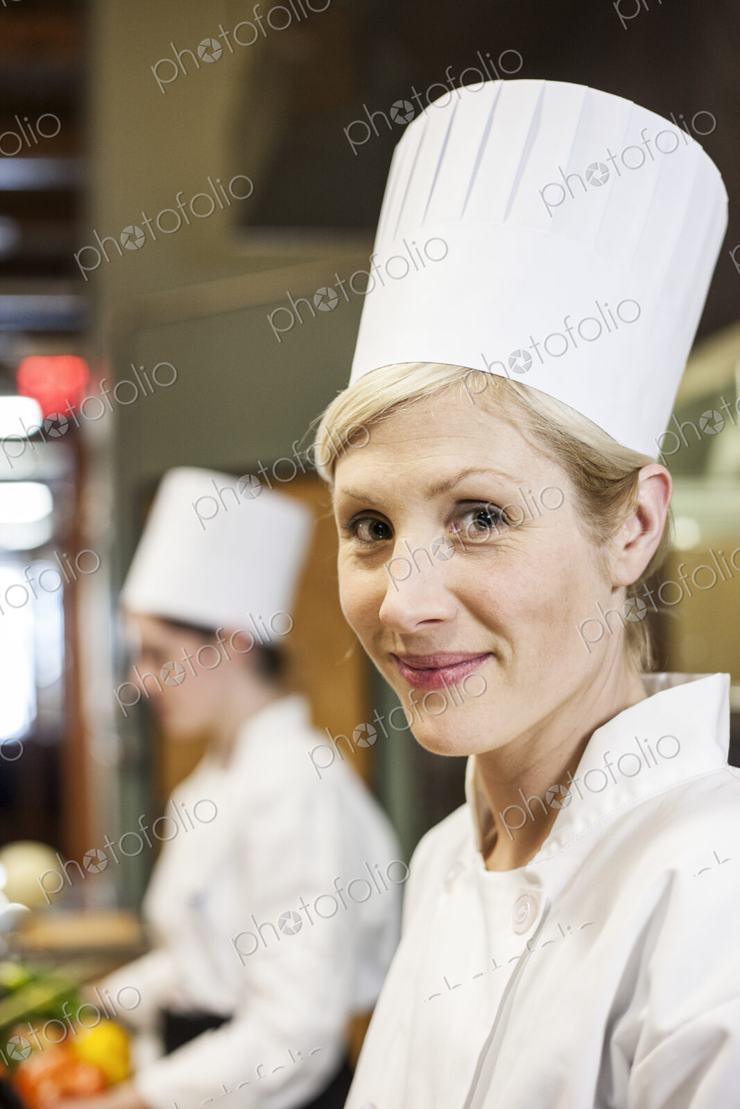 A portrait of a caucasian female chef in a commercial kithchen.