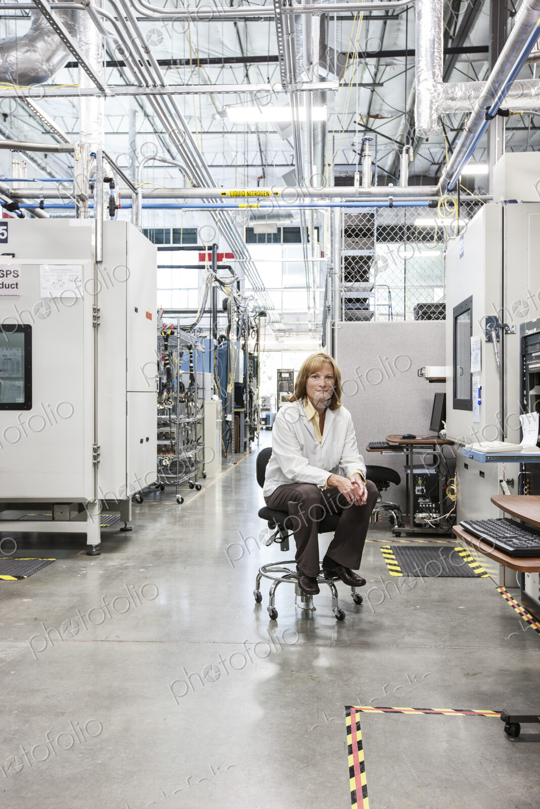 A portrait of a caucasian female technician in a technical research and development site.