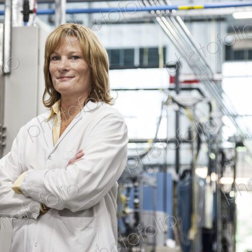 A portrait of a caucasian female technician in a technical research and development site.
