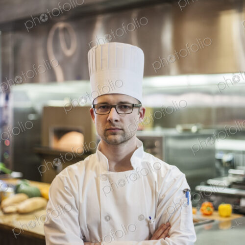 A portrait of a caucasian male chef in a commercial kitchen. A portrait of a caucasian male chef in a commercial kitchen.