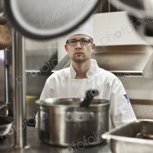 A portrait of a caucasian male chef in a commercial kitchen. A portrait of a caucasian male chef in a commercial kitchen.