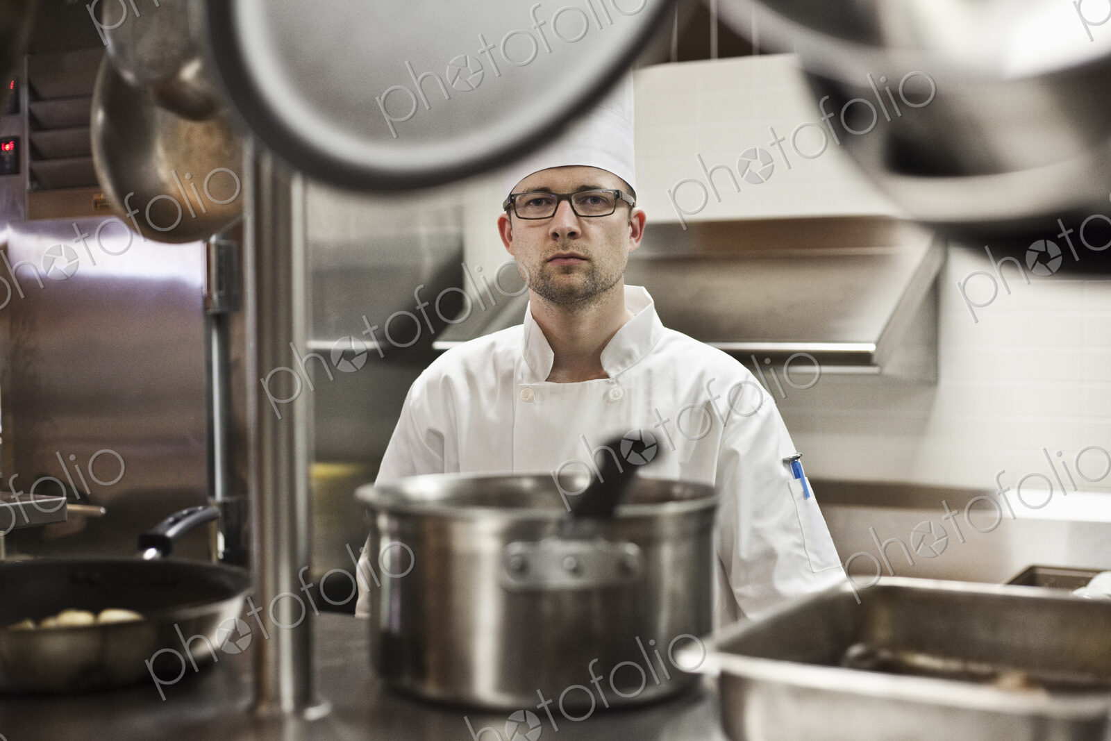 A portrait of a caucasian male chef in a commercial kitchen.