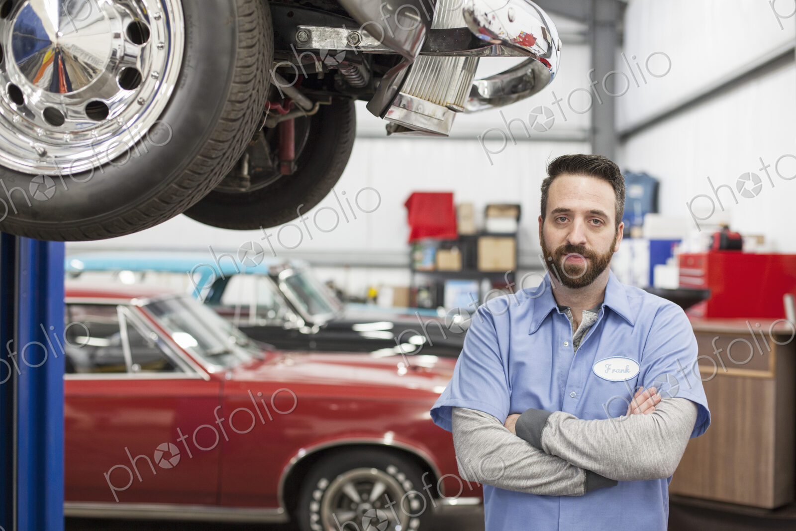A portrait of a caucasian mechanic in his classic car repair shop.