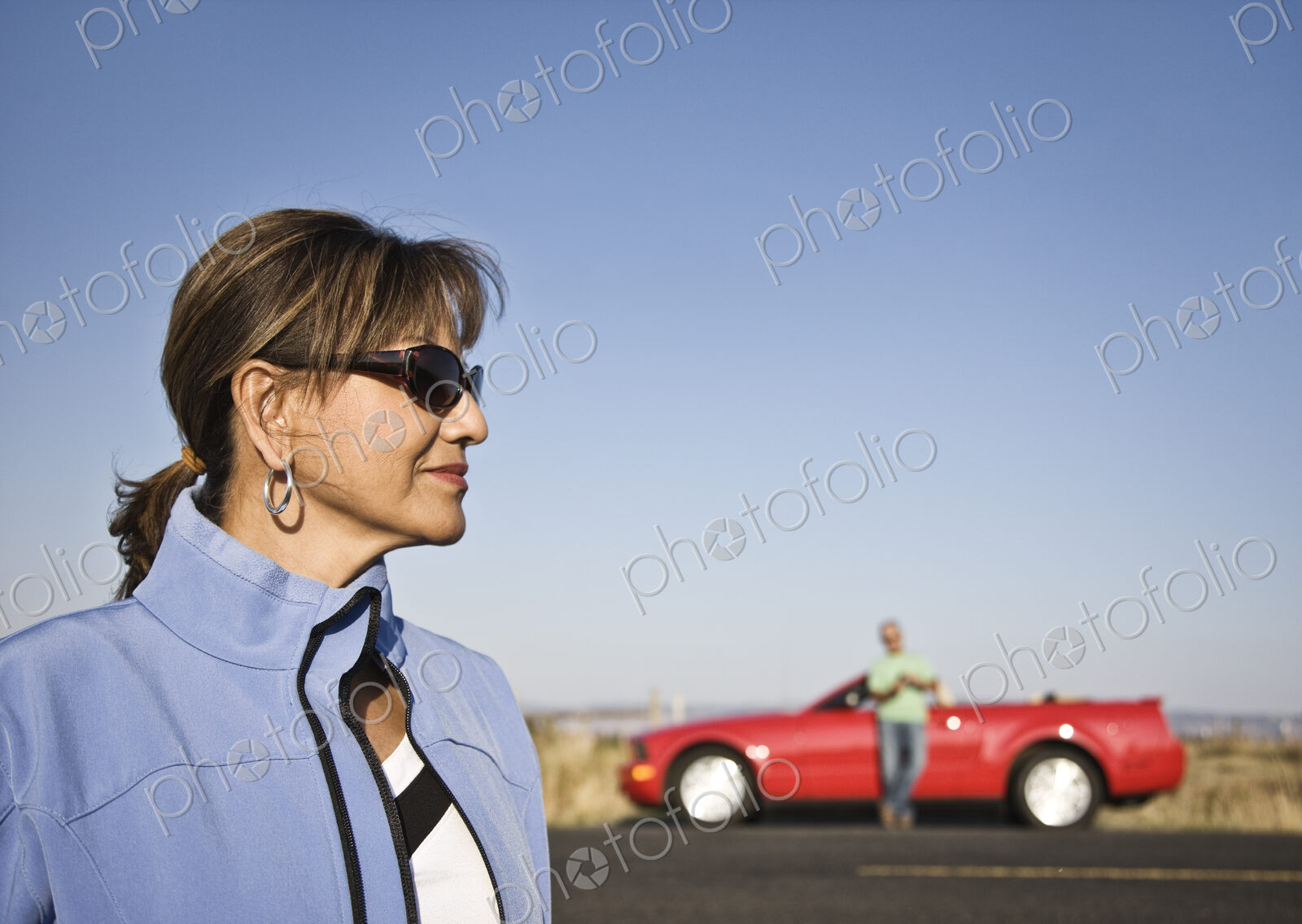 A portrait of a hip senior Hispanic woman on a road trip with her husband.